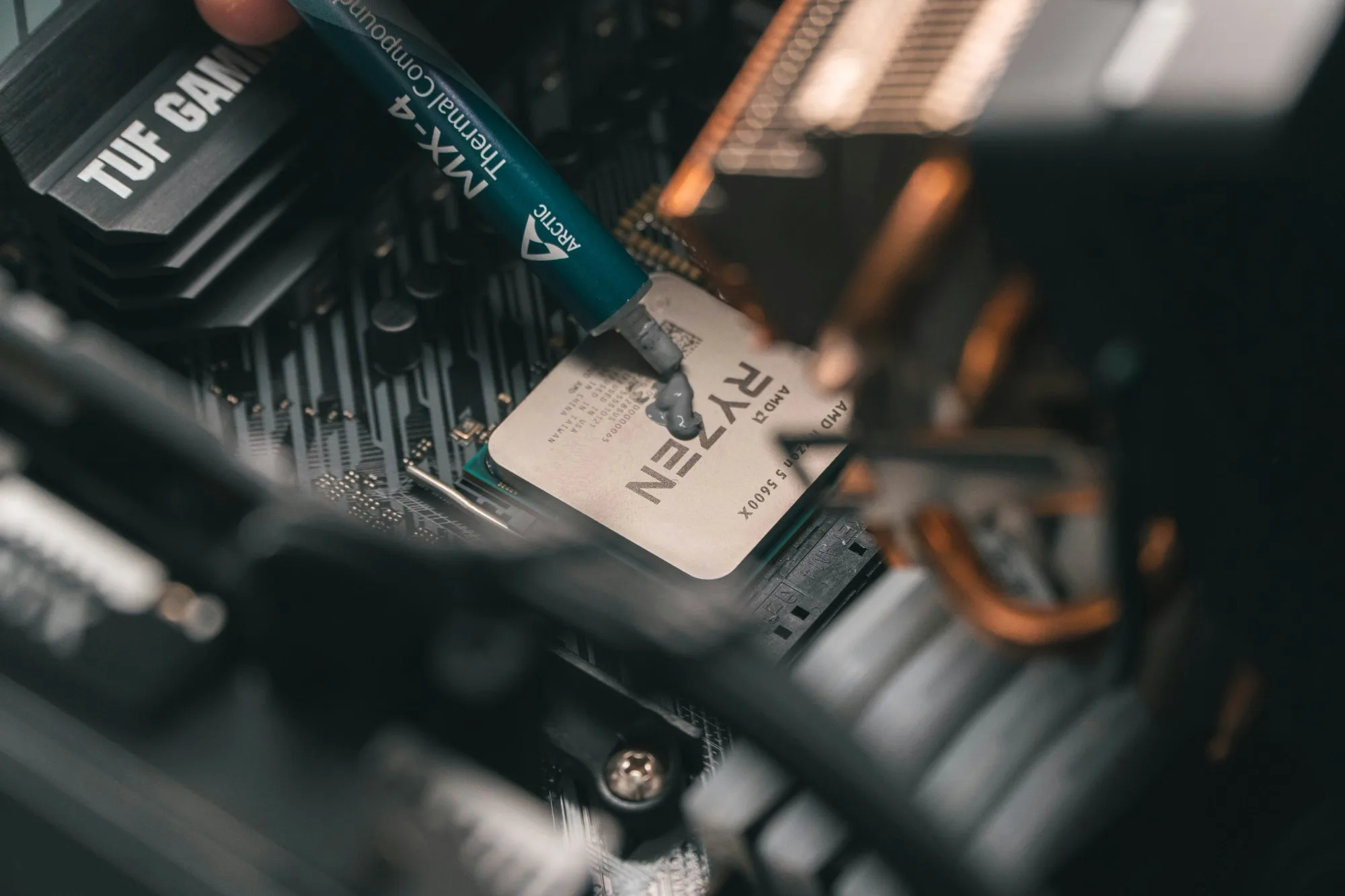 Thermal paste being applied to an AMD Ryzen processor on a motherboard